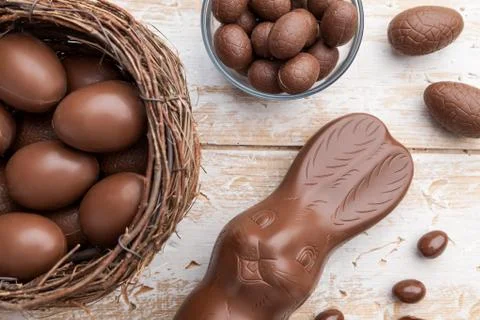 Chocolate Easter bunny, eggs and sweets on rustic background Stock Photos