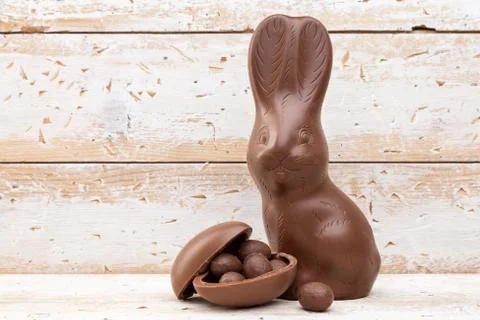 Chocolate Easter bunny, eggs and sweets on rustic background Stock Photos