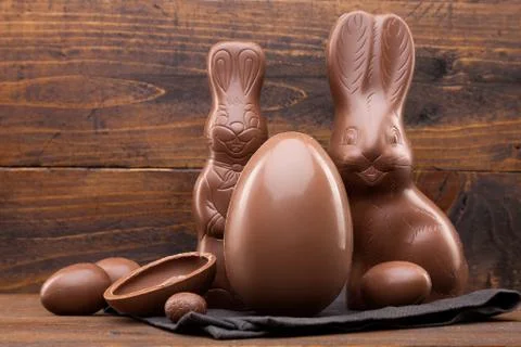 Chocolate Easter bunny, eggs and sweets on rustic background Stock Photos