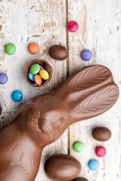 Chocolate Easter bunny, eggs and sweets on rustic background Stock Photos