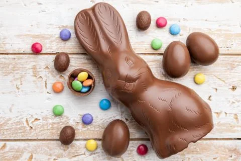 Chocolate Easter bunny, eggs and sweets on rustic background Stock Photos
