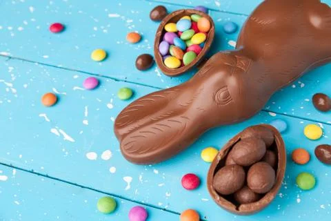 Chocolate Easter bunny, eggs and sweets on rustic background Stock Photos