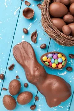 Chocolate Easter bunny, eggs and sweets on rustic background Stock Photos