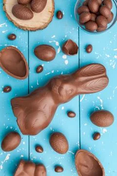 Chocolate Easter bunny, eggs and sweets on rustic background Stock Photos