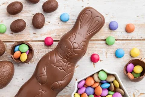 Chocolate Easter bunny, eggs and sweets on rustic background Stock Photos