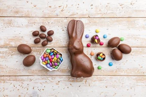 Chocolate Easter bunny, eggs and sweets on rustic background Stock Photos