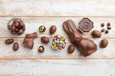 Chocolate Easter bunny, eggs and sweets on rustic background Stock Photos