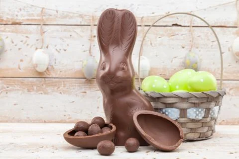 Chocolate Easter bunny, eggs and sweets on rustic background Stock Photos