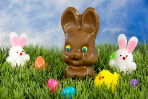 Chocolate Easter bunny in grass with eggs Stock Photos