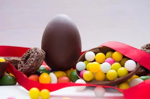 Chocolate easter egg with candy and red ribbon Stock Photos