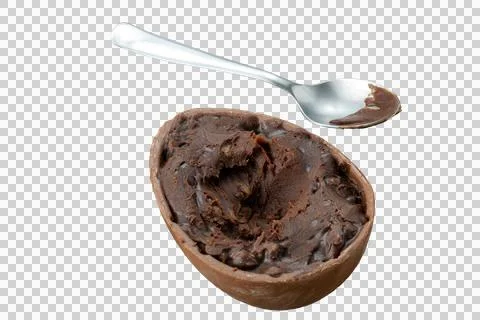 Chocolate easter egg filled with nuts and dark chocolate next to a spoon. Stock Photos