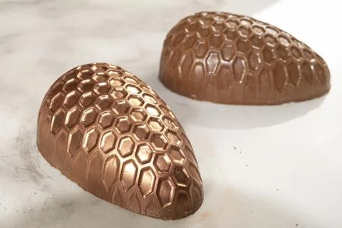 Chocolate Easter egg with honeycomb texture decorated with edible copper powd Fotos de archivo
