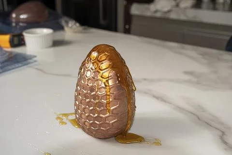 Chocolate Easter egg with honeycomb texture covered with honey. Fotos de archivo