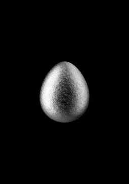 Chocolate easter egg with silver Aluminium foil on black background. Stock Photos
