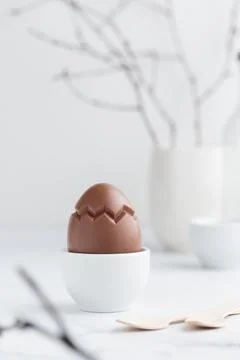 Chocolate easter egg in a white eggholder Stock Photos