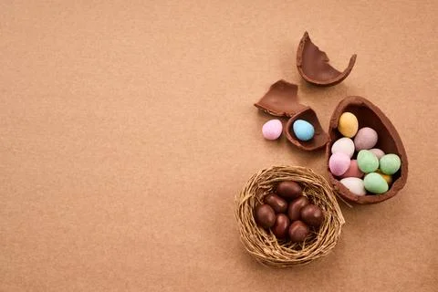 Chocolate easter eggs and candy scattered on brown background Foto stock