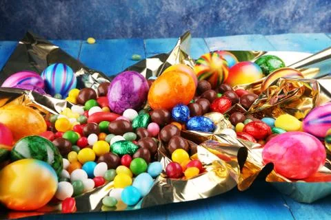 Chocolate Easter eggs and fresh eggs and colorful sweets Stock Photos