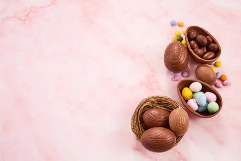 Chocolate easter eggs and nests on pink marble Stock Photos