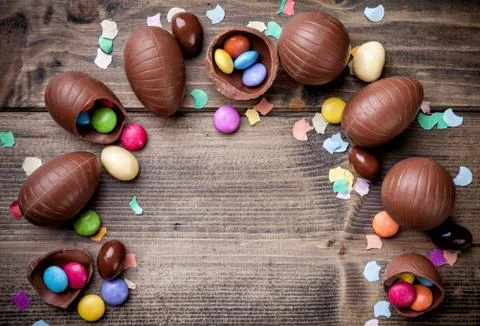 Chocolate easter eggs and sweets on wooden background Stock Photos