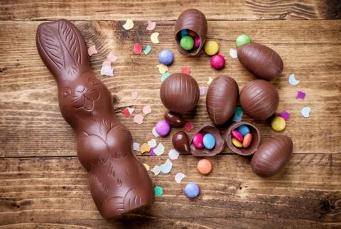 Chocolate easter eggs and sweets on wooden background Stock Photos