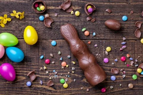 Chocolate easter eggs and sweets on wooden background Stock Photos