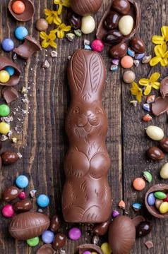 Chocolate easter eggs and sweets on wooden background Stock Photos