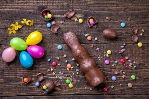 Chocolate easter eggs and sweets on wooden background Stock Photos