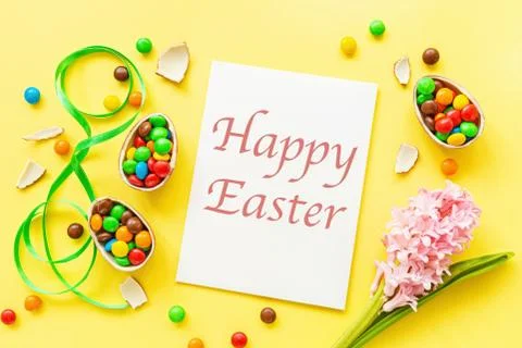 Chocolate Easter eggs, blank of paper with transcription Happy Easter and col Stock Photos
