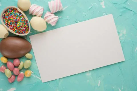 Chocolate easter eggs with a colored dragee. A top view, on a colored backgro Stock Photos