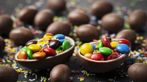 Chocolate Easter eggs with colorful candy Stock Photos