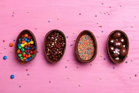 Chocolate easter eggs with colorful sprinkles on pink background Stock Photos