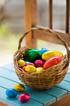 Chocolate Easter eggs in coloured foil in basket Stock Photos