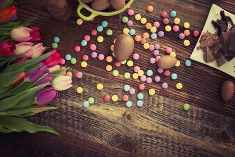Chocolate easter eggs, dragee and tulips Stock Photos
