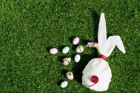 Chocolate Easter eggs glazed with pastel coloring and quail eggs over green g Stock Photos
