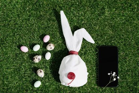 Chocolate Easter eggs glazed with pastel coloring and quail eggs over green g Stock Photos