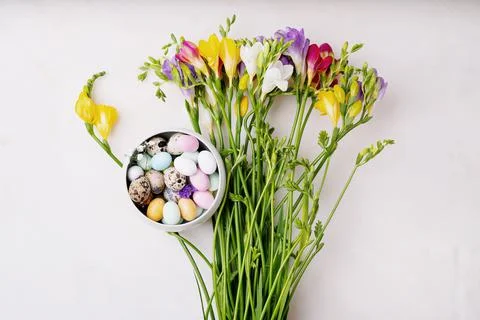 Chocolate Easter eggs glazed with pastel coloring and quail eggs in a bowl ov Stock Photos