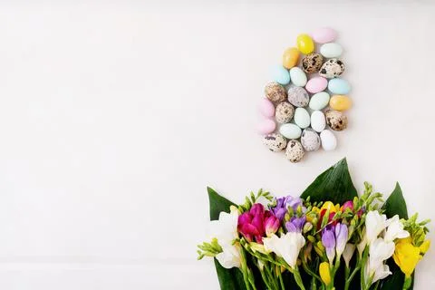 Chocolate Easter eggs glazed with pastel coloring and quail eggs over white b Stock Photos
