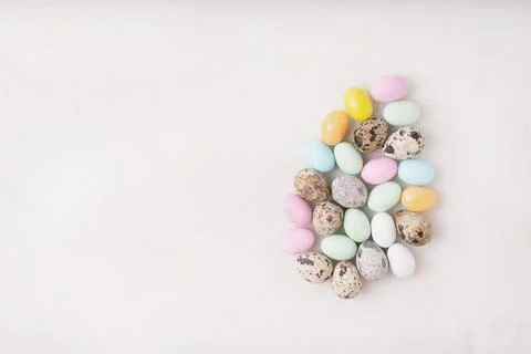 Chocolate Easter eggs glazed with pastel coloring and quail eggs over white b Stock Photos