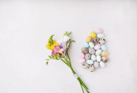 Chocolate Easter eggs glazed with pastel coloring and quail eggs over white b Stock Photos