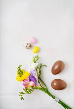 Chocolate Easter eggs glazed with pastel coloring and quail eggs over white b Stock Photos
