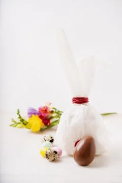 Chocolate Easter eggs glazed with pastel coloring and quail eggs over white b Stock Photos