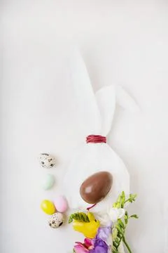 Chocolate Easter eggs glazed with pastel coloring and quail eggs over white b Stock Photos