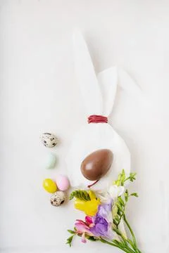 Chocolate Easter eggs glazed with pastel coloring and quail eggs over white b Stock Photos