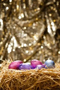 Chocolate easter eggs in a natural straw nest Stock Photos