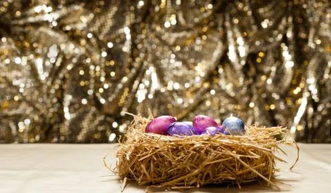Chocolate easter eggs in a natural straw nest Stock Photos