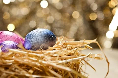 Chocolate easter eggs in a natural straw nest Stock Photos
