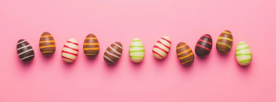 Chocolate easter eggs on pink background. Stock Photos
