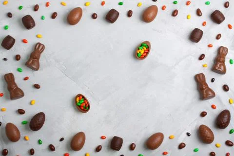 Chocolate easter eggs, rabbits, casks and sweets on concrete background Stock Photos