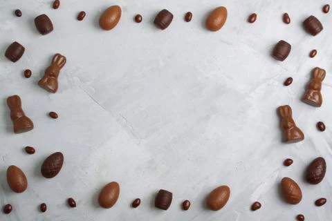 Chocolate easter eggs, rabbits, casks and sweets on concrete background Stock Photos