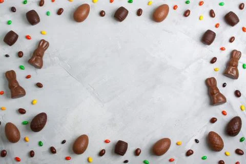 Chocolate easter eggs, rabbits, casks and sweets on concrete background Stock Photos